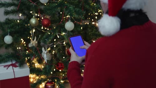 Christmas User Navigates Smartphone in Festive Setting