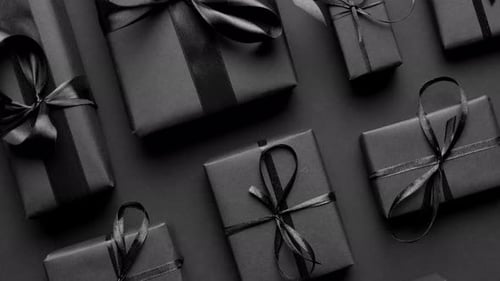 Dark Christmas Theme. Square Boxed Gifts Wrapped in Black Paper and Ribbon Arranged on Black