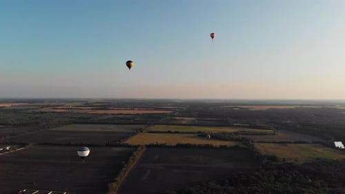 Beautiful balloons fly over the forest, park, city.