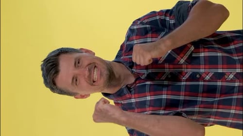 Man Pumping Fists in Front of Yellow Background