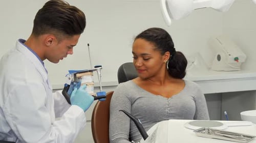 Dentist Showing Dental Model to Patient in Office