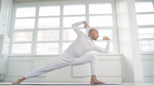 Bald Man Practicing Yoga in Bright Studio
