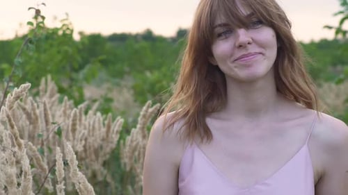 Closeup Portrait of a Young Attractive Redhaired Woman in a Field with Spikelets