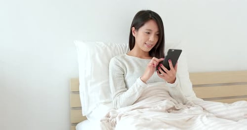 Woman use of smart phone on bed