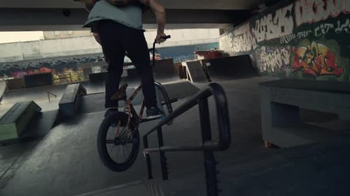 Sporty Rider Performing Tricks on Bmx Bicycle in City Skateboarding Park