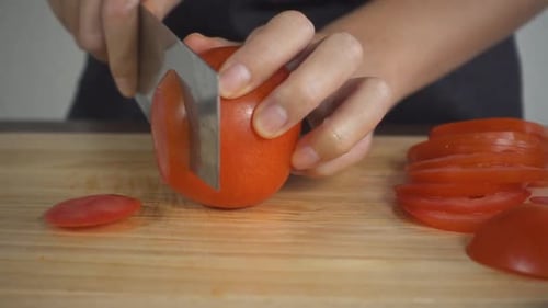 Slicing Fresh Red Tomato on Cutting Board