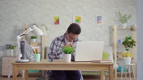 Young Adult Coughing at Desk with Chest Pain