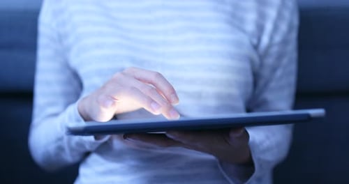 Adult Using Tablet Device Technology in Dark