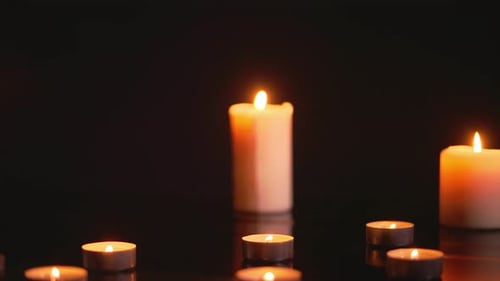 Burning Candles Glowing in the Dark