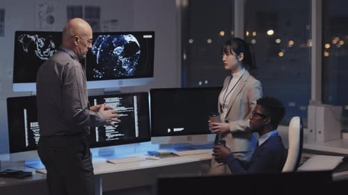 Colleagues Discuss Code in an Urban Office at Night