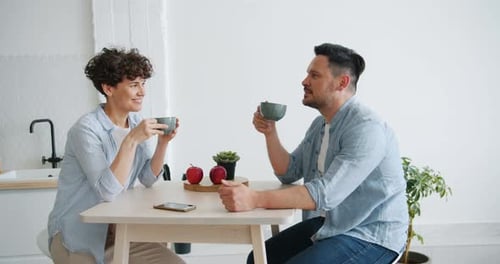Couple Having Coffee and Talking in Kitchen