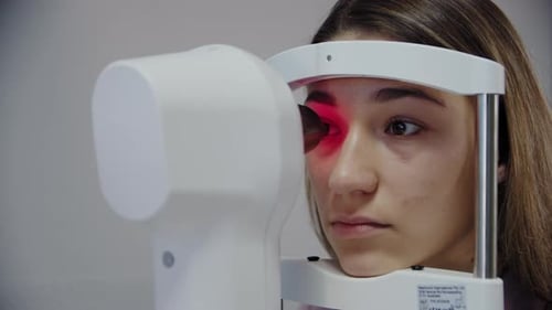 Nahaufnahme eines Augenarztes untersucht das Auge des Patienten und schaut dann in die Kamera