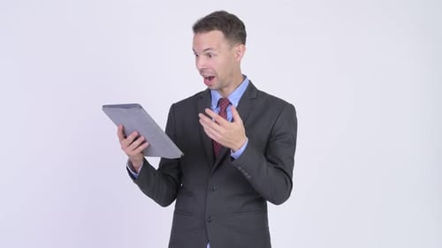 Studio Shot of Happy Businessman Using Digital Tablet and Looking Surprised