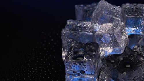Close up ice cubes rotating on black background