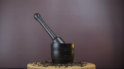 Dark Mortar and Pestle with Black Peppercorns
