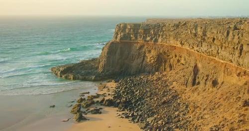 Rocky Coastline Alongside Cliffside with Blue Atlantic Ocean Water at Sunset