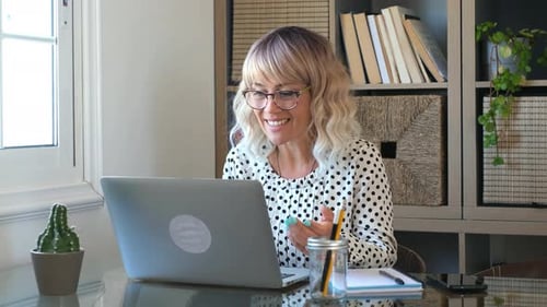 Smiling Woman Having Video Call on Laptop at Home
