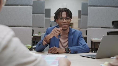 Young Man Presenting in Modern Office Environment