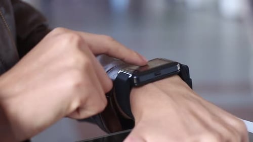 Mädchen benutzt eine intelligente schwarze Smartwatch im Zimmer