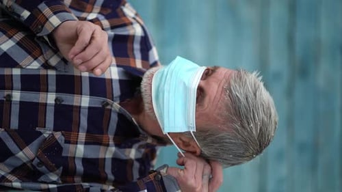 Senior Adult Putting on a Protective Face Mask