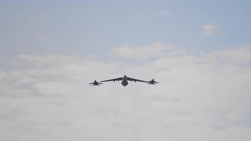 Cargo Plane Escorted by Fighter Jets in Flight