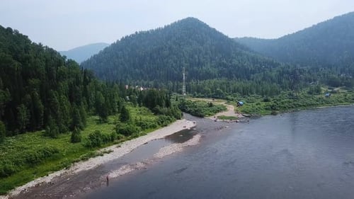Drone Flies Over River in Mountainous Countryside.