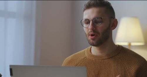 Un spécialiste masculin prend la parole lors d'une réunion en ligne avec des collègues communiquant avec les gens à distance