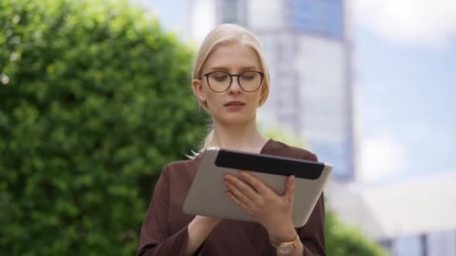 Business Woman Using Tablet Outdoors in Urban Setting