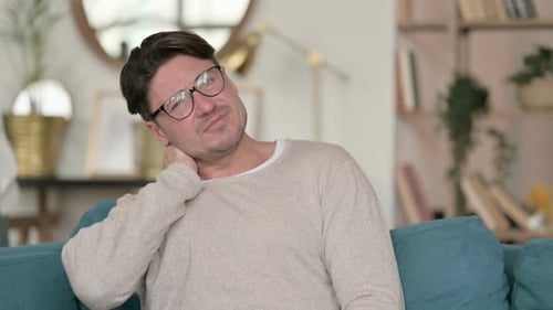 Man Tilting Head with Neck Pain Indoors