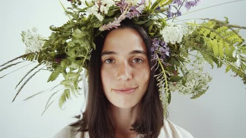 Joyous Woman in Flower Wreath Smiling at Camera in Studio