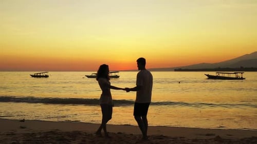 Young couple happy together on tranquil coastline beach wildlife by blue ocean and white sand backgr