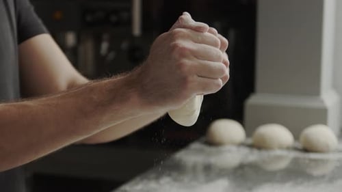 Adult Shaping Ball of Dough in Restaurant Kitchen