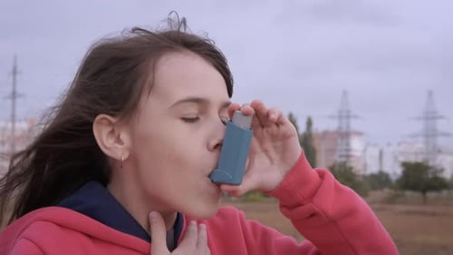 Teen Girl Using Inhaler Outside