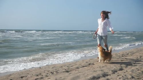 Girl With The Corgi Dog Running By The Sea Shore