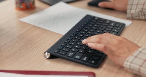 Closeup of a Black Keyboard From a Computer Standing on a Wooden Desk on It a Working Woman Young