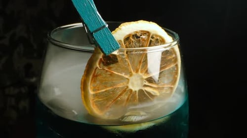 Alkoholisches Getränk mit Zitrone. Rauch. Nahaufnahme.