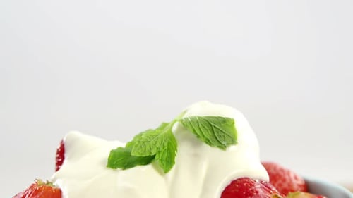Close-up of fresh strawberries with cream in bowl