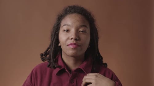 Portrait of Charming African-American Woman Fixing Shirt Collar