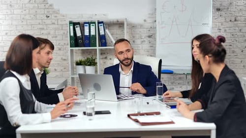 Fashion Male Boss in Suit Talking with Employee Having Corporate Team Meeting at Modern Light Office
