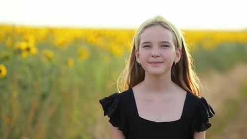Girl Stands in Pretty Sunflower Field