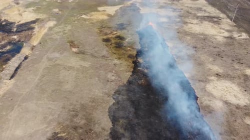 Burning Field Consumed by Flames and Billowing Smoke