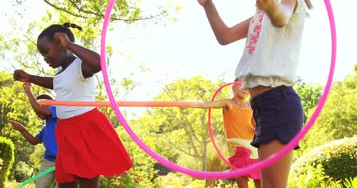 Children Play Hula Hoop Game in the Park