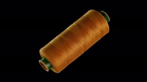 Gold Colored Sewing Thread on a Black Background