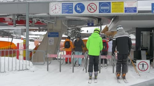 People waiting for ski lift on snowy day