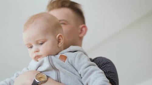 Father Holds Baby in Interior Setting