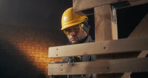 Man with Hard Hat Working on Wooden Structure