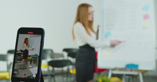 Woman Teaching with Whiteboard being Recorded on Phone
