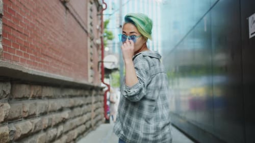 Stylish Young Woman Walks in City Alleyway