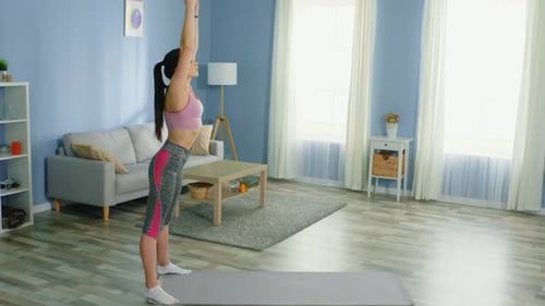 Woman Doing Forward Bend Stretch in Living Room