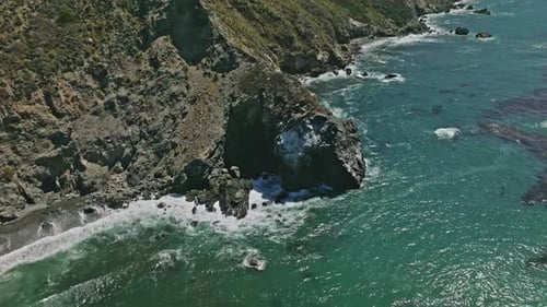 Aerial Top View of Ocean Blue Waves Break on a Coastline